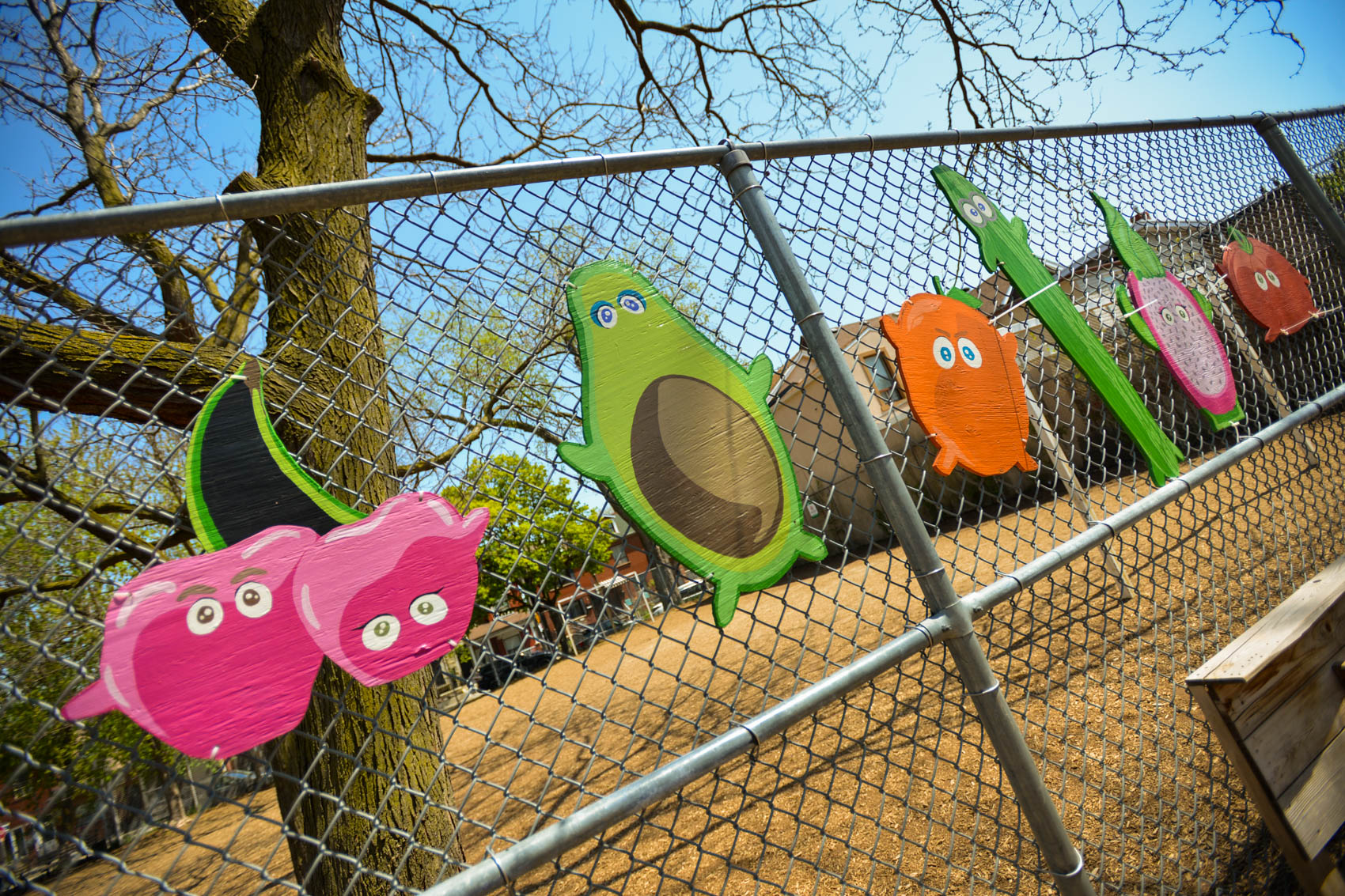 Painted wooden antropomorphic fruit on the brock playground fence