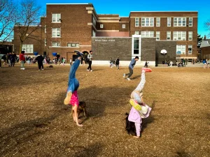 Two children cartwheeling in the Brock School yard