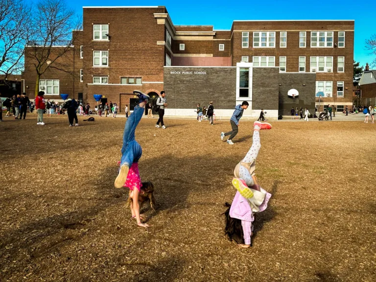 Two children cartwheeling in the Brock School yard